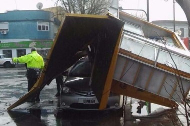 Por el fuerte temporal, un puesto de diarios terminó arriba de un auto